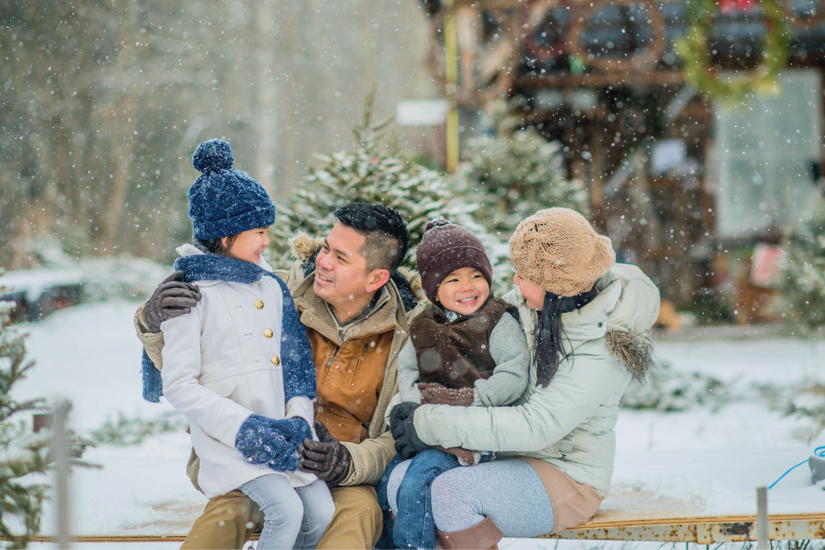 A family enjoys a winter outing at a tree farm, reflecting the joy of holiday traditions while staying mindful of seasonal spending.